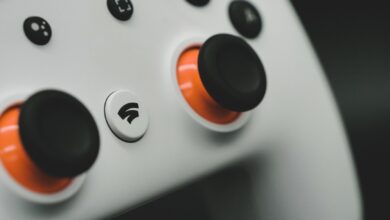 Detailed close-up of a modern white gaming controller featuring vibrant orange buttons.