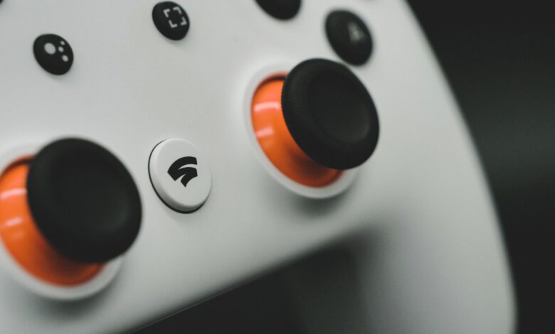 Detailed close-up of a modern white gaming controller featuring vibrant orange buttons.