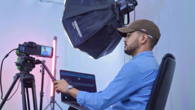 A photographer works in a studio with advanced camera and lighting equipment, showcasing professional filming.