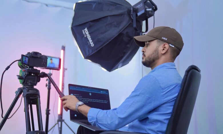 A photographer works in a studio with advanced camera and lighting equipment, showcasing professional filming.