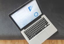 Overhead view of a laptop showing data visualizations and charts on its screen.