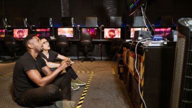 Two diverse men focused on gaming in a modern arcade setting, showcasing technology and camaraderie.