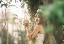 Captivating fairy with floral crown in mystical forest setting, evoking fantasy and magic.