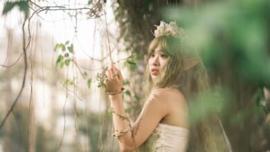 Captivating fairy with floral crown in mystical forest setting, evoking fantasy and magic.