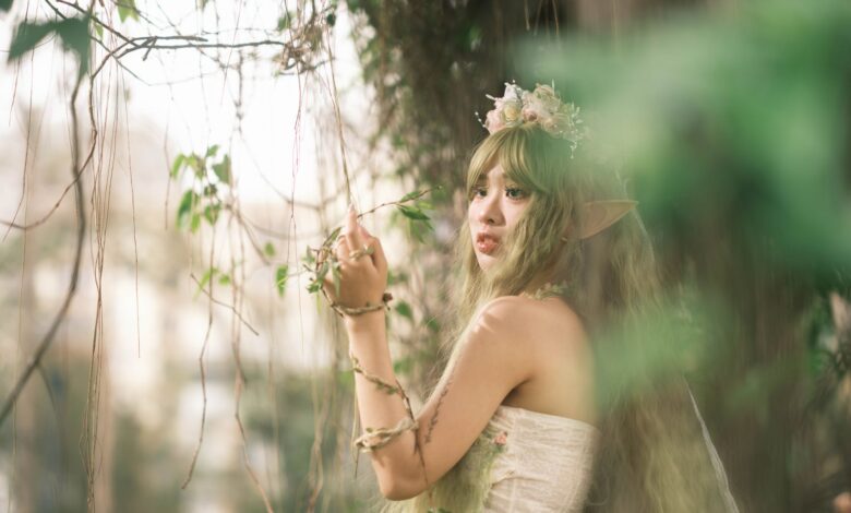 Captivating fairy with floral crown in mystical forest setting, evoking fantasy and magic.