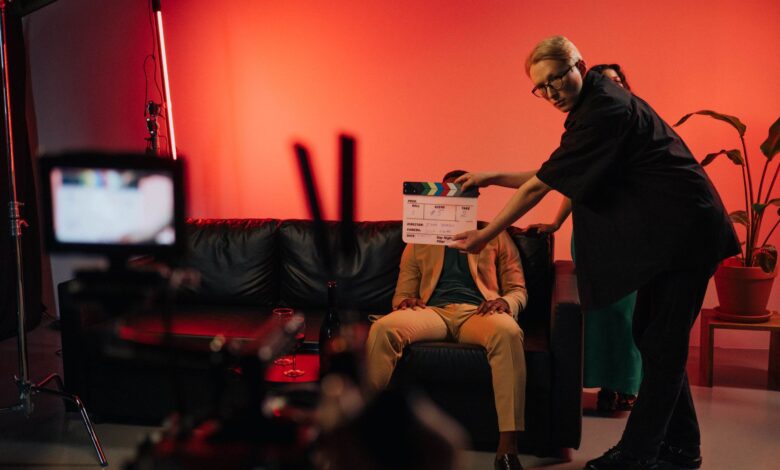 Film production team setting up a scene on an indoor set with dramatic lighting.
