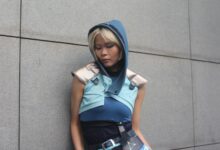 Person in a blue fantasy costume against a concrete wall.