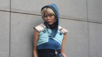 Person in a blue fantasy costume against a concrete wall.