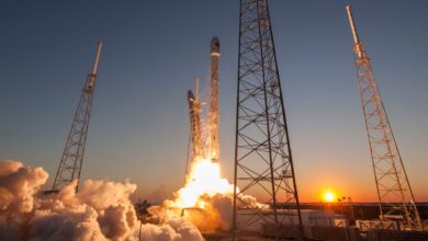 Low angle of modern rocket taking off into cloudless sky during beautiful sunset over space factory