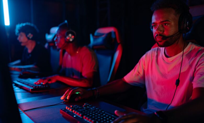 Young men engrossed in a competitive eSports gaming session, displaying teamwork and focus.