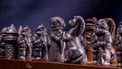 Close-up of metallic medieval chess pieces on a board, capturing the craftsmanship and detail.