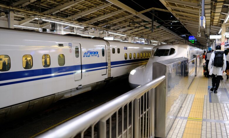 Shinkansen bullet train at a busy Tokyo station platform with passengers boarding.