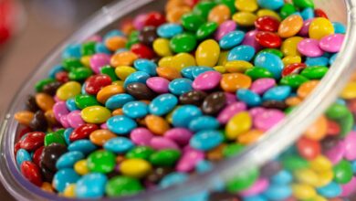 A glass bowl filled with colorful candy-coated chocolates, perfect for a festive party setting.