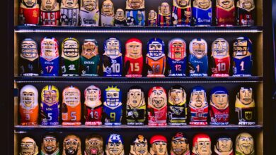 Colorful nesting dolls depicting various sports teams displayed on shelves.
