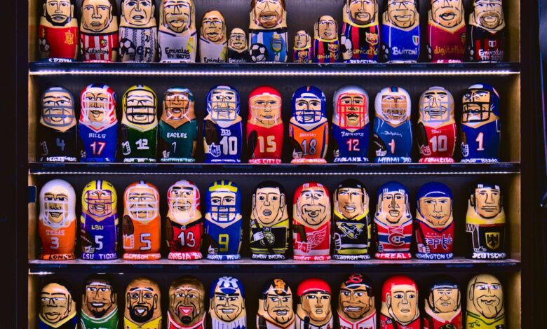 Colorful nesting dolls depicting various sports teams displayed on shelves.