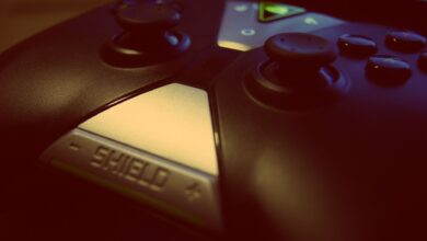 Close-up view of a modern gaming controller, highlighting joystick and buttons with a 'shield' design.