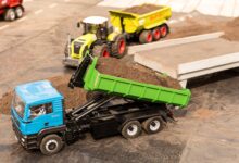 High-angle view of toy trucks on a model construction site showcasing a realistic mini landscape.