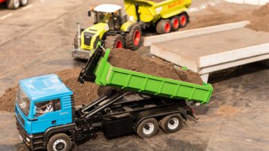High-angle view of toy trucks on a model construction site showcasing a realistic mini landscape.