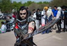A man in detailed warrior cosplay at an outdoor festival, captivating portrait.