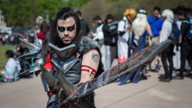 A man in detailed warrior cosplay at an outdoor festival, captivating portrait.