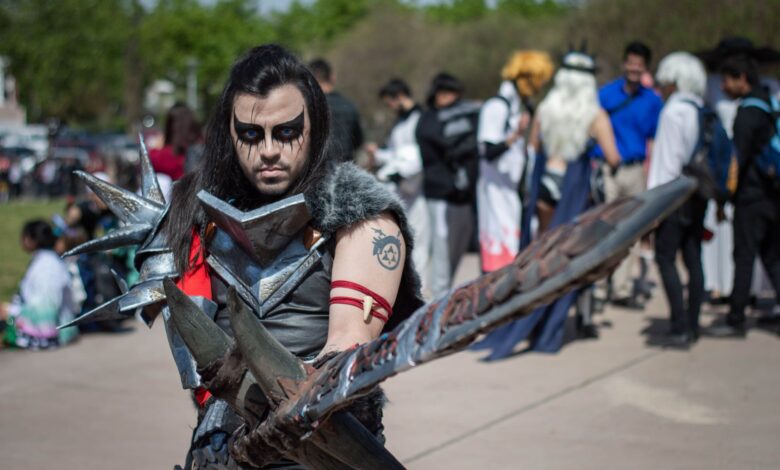 A man in detailed warrior cosplay at an outdoor festival, captivating portrait.