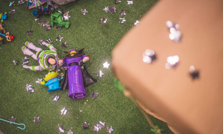 Buzz Lightyear and Zurg toy figures on artificial grass surrounded by star-shaped decorations.