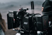Close-up of a professional filmmaking camera setup on an outdoor set with blurred background.