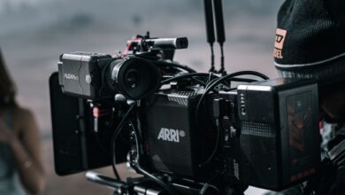 Close-up of a professional filmmaking camera setup on an outdoor set with blurred background.