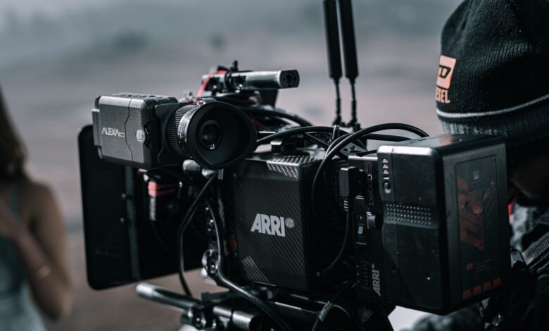 Close-up of a professional filmmaking camera setup on an outdoor set with blurred background.