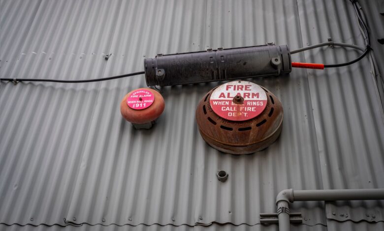 An industrial fire alarm system mounted on a corrugated metal wall for safety and security.