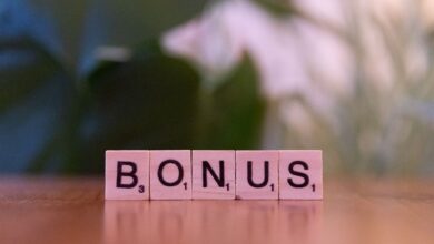 Close-up of the word BONUS spelled with Scrabble tiles on a table.