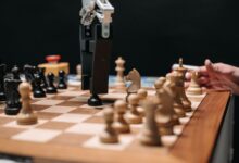 Close-up of a robotic arm playing chess against a human, showcasing AI technology in a classic board game setting.