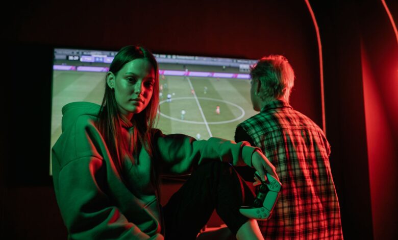 Two young adults playing video games intensely indoors with gaming controllers.
