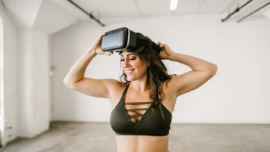 Cheerful woman in sportswear enjoying virtual reality experience indoors.