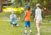 A family enjoying a game of velcro ball in a sunny park, showcasing togetherness and fun.