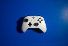 White wireless game controller on a vibrant blue backdrop, perfect for gaming-related content.