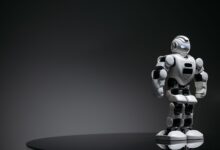 Compact humanoid robot toy standing on a reflective surface, exuding a futuristic vibe.