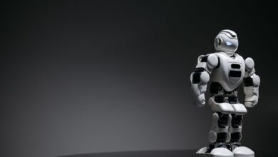 Compact humanoid robot toy standing on a reflective surface, exuding a futuristic vibe.