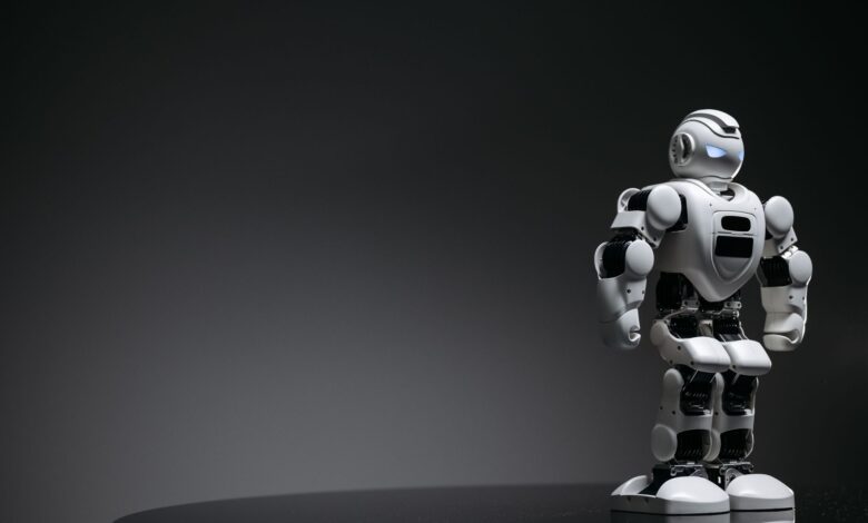 Compact humanoid robot toy standing on a reflective surface, exuding a futuristic vibe.