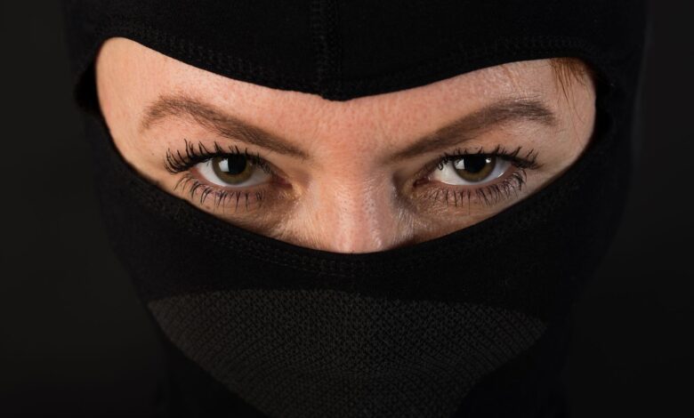 Intense close-up shot of eyes partially covered by a black mask, conveying mystery.