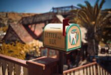 A vintage mailbox with dental artwork in a sunny outdoor setting.