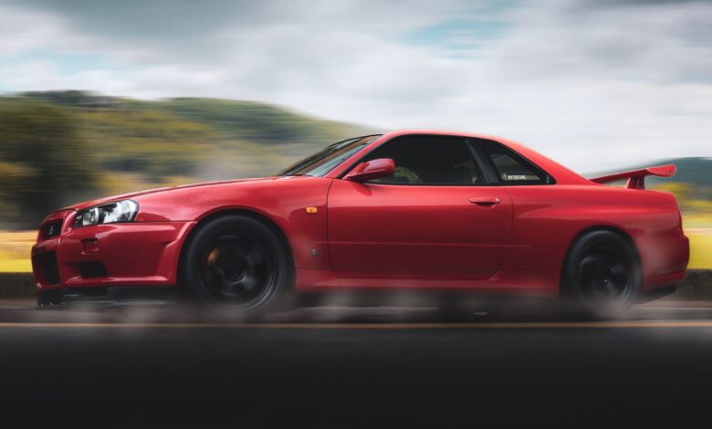 Vibrant red sports car speeds along a scenic highway, showcasing sleek design and performance.
