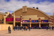 Visitors enter the vibrant Studio Theater entrance at Disneyland Paris on a sunny day.