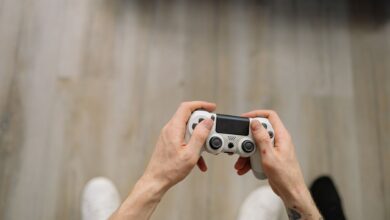 Overhead shot of hands with tattoos holding a game controller, ready for gaming.