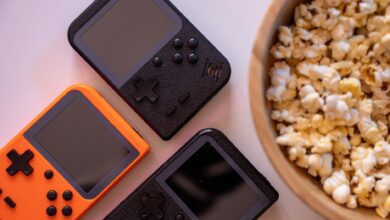 Close-up of retro handheld game consoles and popcorn, perfect for gaming nights.
