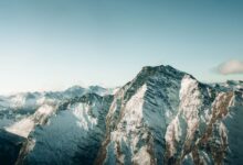 Aerial view of snow-covered mountains in Queenstown, New Zealand, showcasing breathtaking winter scenery.