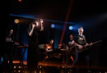 Dynamic live music performance featuring a rock band with singer and instruments on stage.