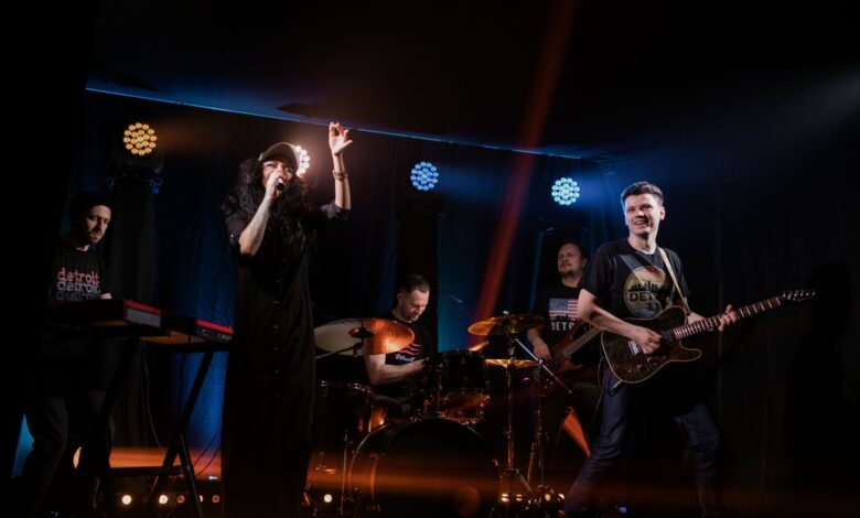Dynamic live music performance featuring a rock band with singer and instruments on stage.