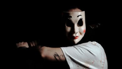 A mysterious figure wearing a mask creates a chilling atmosphere on a dark background.