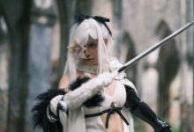 A striking image of a cosplayer in gothic attire wielding a sword in a historical setting in Vietnam.
